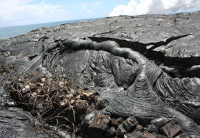 Recent lava overtaking old beach rock wall